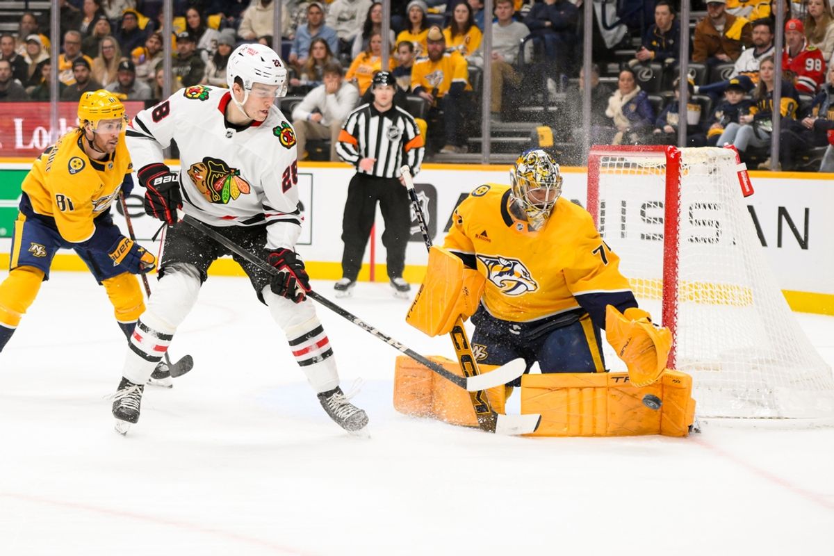 Jan 16, 2025; Nashville, Tennessee, USA;  Nashville Predators goaltender Juuse Saros (74) blocks the deflection of Chicago Blackhawks center Colton Dach (28) during the second period at Bridgestone Arena. Mandatory Credit: Steve Roberts-Imagn Images