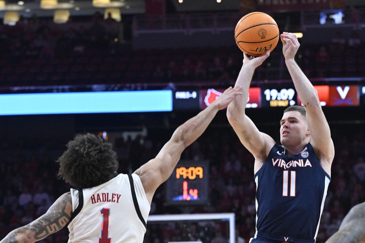 Jan 18, 2025; Louisville, Kentucky, USA;  Virginia Cavaliers guard Isaac McKneely (11) shoots against Louisville Cardinals guard J'Vonne Hadley (1) during the first half at KFC Yum! Center. Mandatory Credit: Jamie Rhodes-Imagn Images