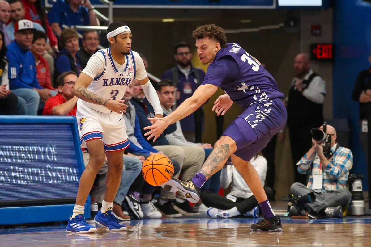 Jan 18, 2025; Lawrence, Kansas, USA; Kansas Jayhawks guard Dajuan Harris Jr. (3) passes the ball away from Kansas State Wildcats forward Coleman Hawkins (33) during the first half at Allen Fieldhouse. Mandatory Credit: Scott Sewell-Imagn Images