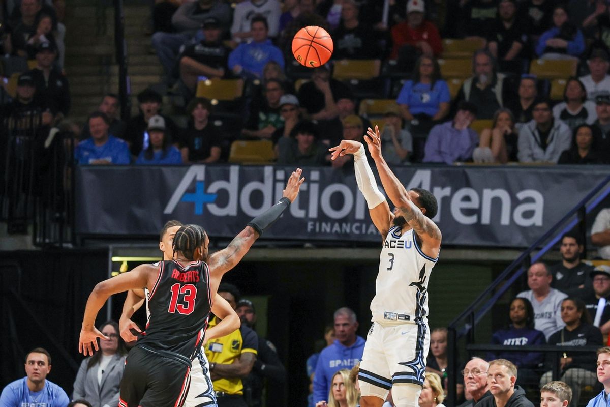 Jan 18, 2025; Orlando, Florida, USA; UCF Knights guard Darius Johnson (3) shoots a three point basket against Houston Cougars forward J'Wan Roberts (13) during the second half at Addition Financial Arena. Mandatory Credit: Mike Watters-Imagn Images