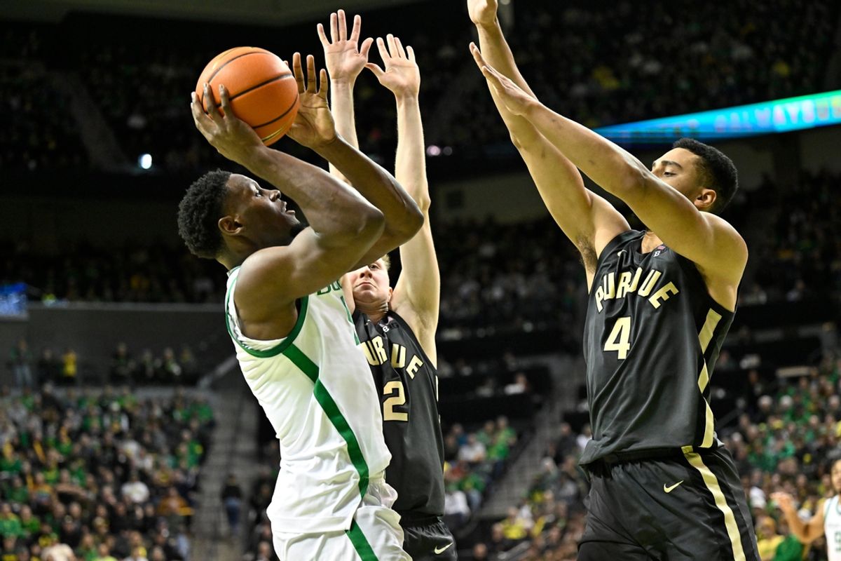 Jan 18, 2025; Eugene, Oregon, USA; Oregon Ducks guard TJ Bamba (5) drives to the basket against Purdue Boilermakers forward Trey Kaufman-Renn (4) and Purdue Boilermakers guard Fletcher Loyer (2) during the first half at Matthew Knight Arena. Mandatory Credit: Craig Strobeck-Imagn Images