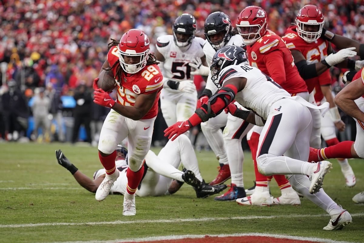 Jan 18, 2025; Kansas City, Missouri, USA; Kansas City Chiefs running back Kareem Hunt (29) carries the ball for a touchdown against Houston Texans linebacker Azeez Al-Shaair (0) during the second quarter of a 2025 AFC divisional round game at GEHA Field at Arrowhead Stadium. Mandatory Credit: Denny Medley-Imagn Images