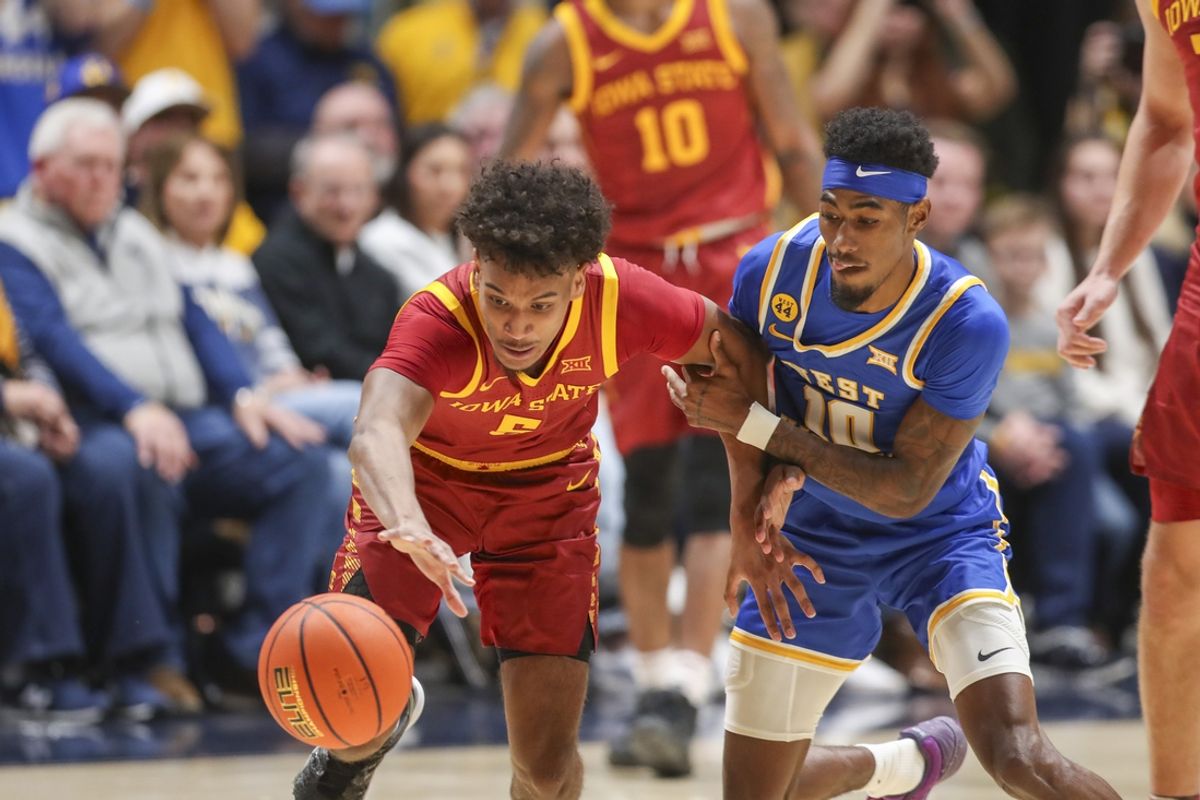 Jan 18, 2025; Morgantown, West Virginia, USA; Iowa State Cyclones guard Curtis Jones (5) and West Virginia Mountaineers guard Sencire Harris (10) fight for a loose ball during the first half at WVU Coliseum. Mandatory Credit: Ben Queen-Imagn Images