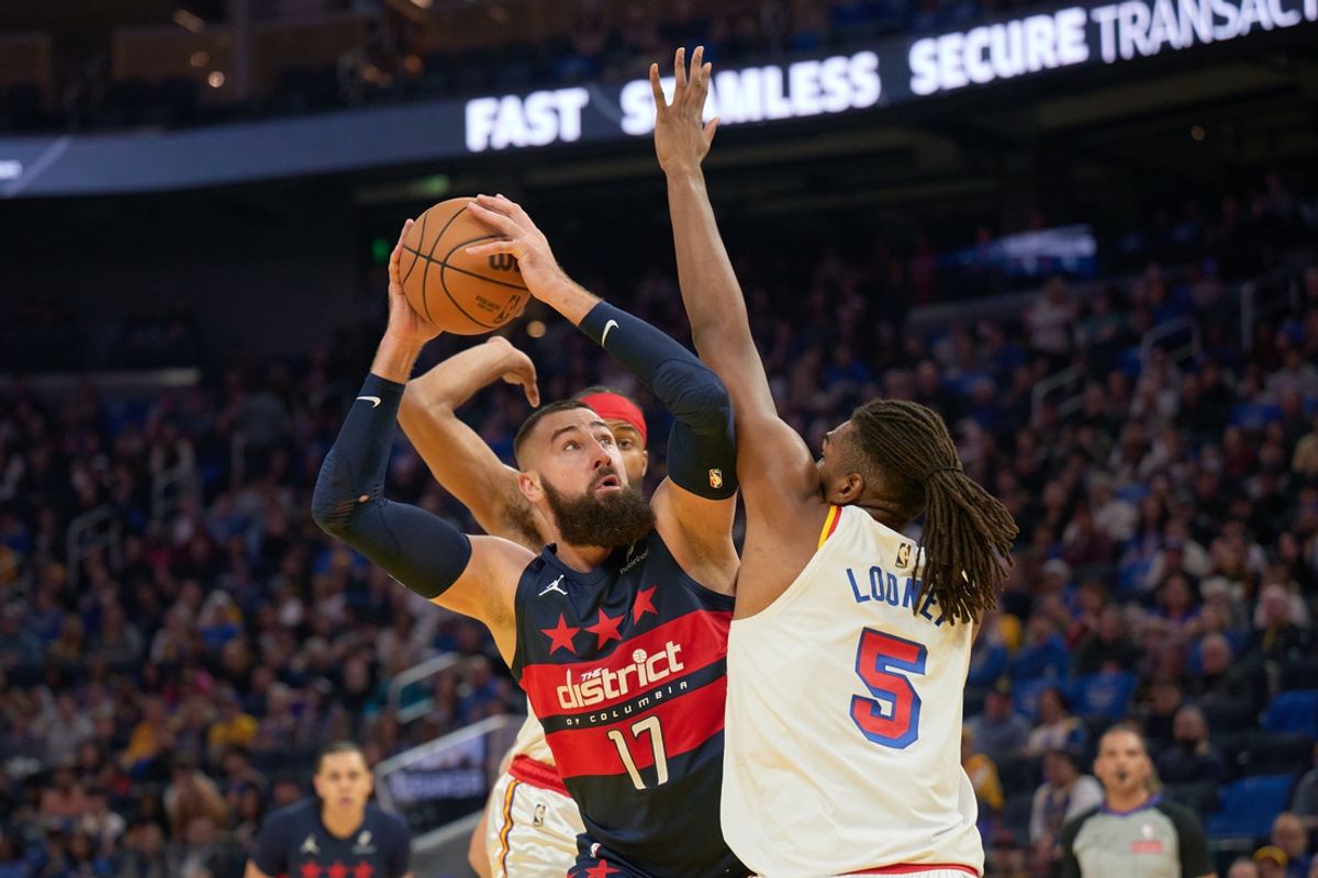 Jan 18, 2025; San Francisco, California, USA; Washington Wizards center Jonas Valanciunas (17) controls the ball against Golden State Warriors forward Kevon Looney (5) during the second quarter at Chase Center. Mandatory Credit: Robert Edwards-Imagn Images