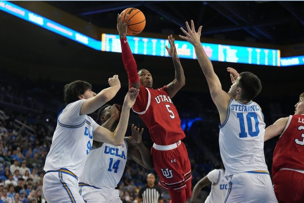 Feb 18, 2024; Los Angeles, California, USA; Utah Utes guard Deivon Smith (5) shoots the ball against forward Kenneth Nwuba (14) and guard Lazar Stefanovic (10) in the first half at Pauley Pavilion presented by Wescom.