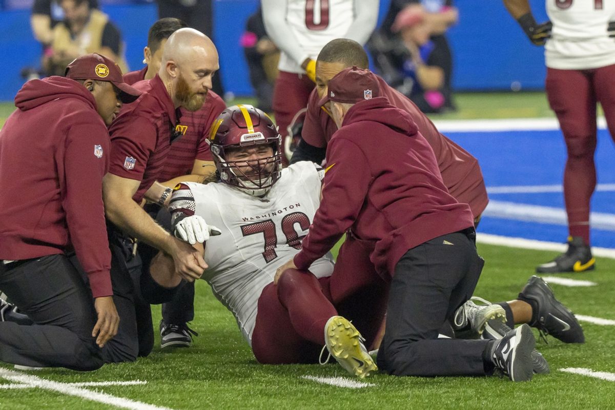 Jan 18, 2025; Detroit, Michigan, USA; Washington Commanders guard Sam Cosmi (76) received medical on the field after an injury during play against Detroit Lions during the second quarter at Ford Field. Mandatory Credit: David Reginek-Imagn Images