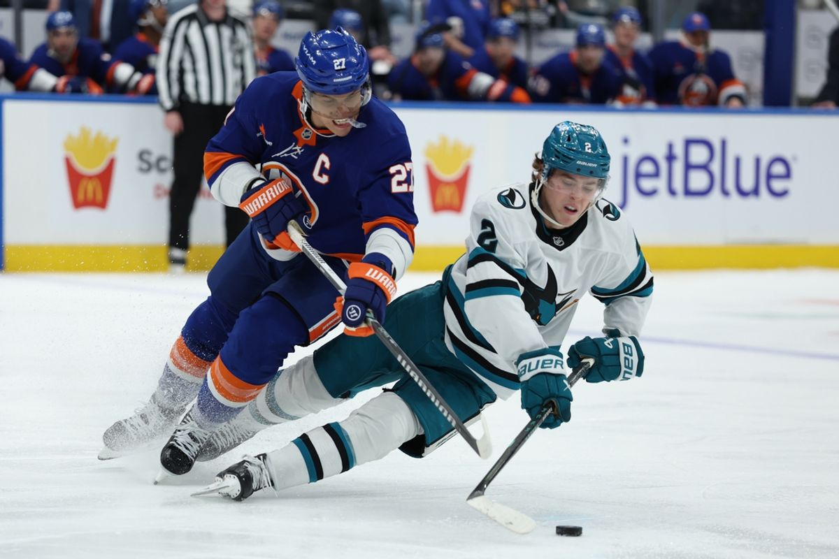 Jan 18, 2025; Elmont, New York, USA;  San Jose Sharks center Will Smith (2) controls the puck as New York Islanders left wing Anders Lee (27) defends during the third period at UBS Arena. Mandatory Credit: Thomas Salus-Imagn Images