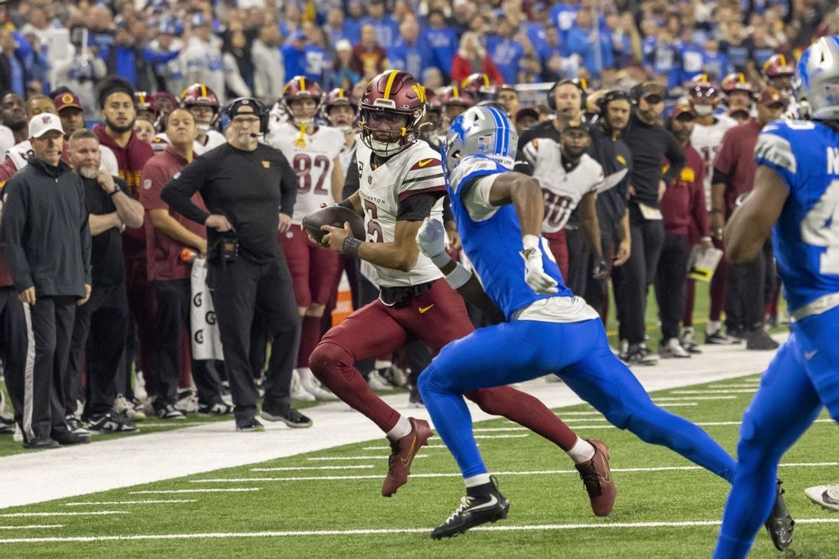 Jan 18, 2025; Detroit, Michigan, USA;  Washington Commanders quarterback Jayden Daniels (5) runs the ball against Detroit Lions during the second half at Ford Field. Mandatory Credit: David Reginek-Imagn Images
