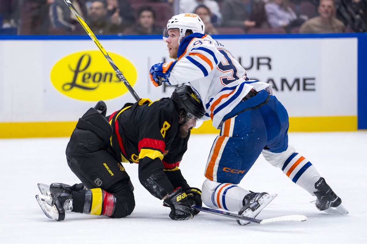 Jan 18, 2025; Vancouver, British Columbia, CAN; Edmonton Oilers forward Connor McDavid (97) battles with Vancouver Canucks forward Conor Garland (8) in the third period at Rogers Arena. Mandatory Credit: Bob Frid-Imagn Images