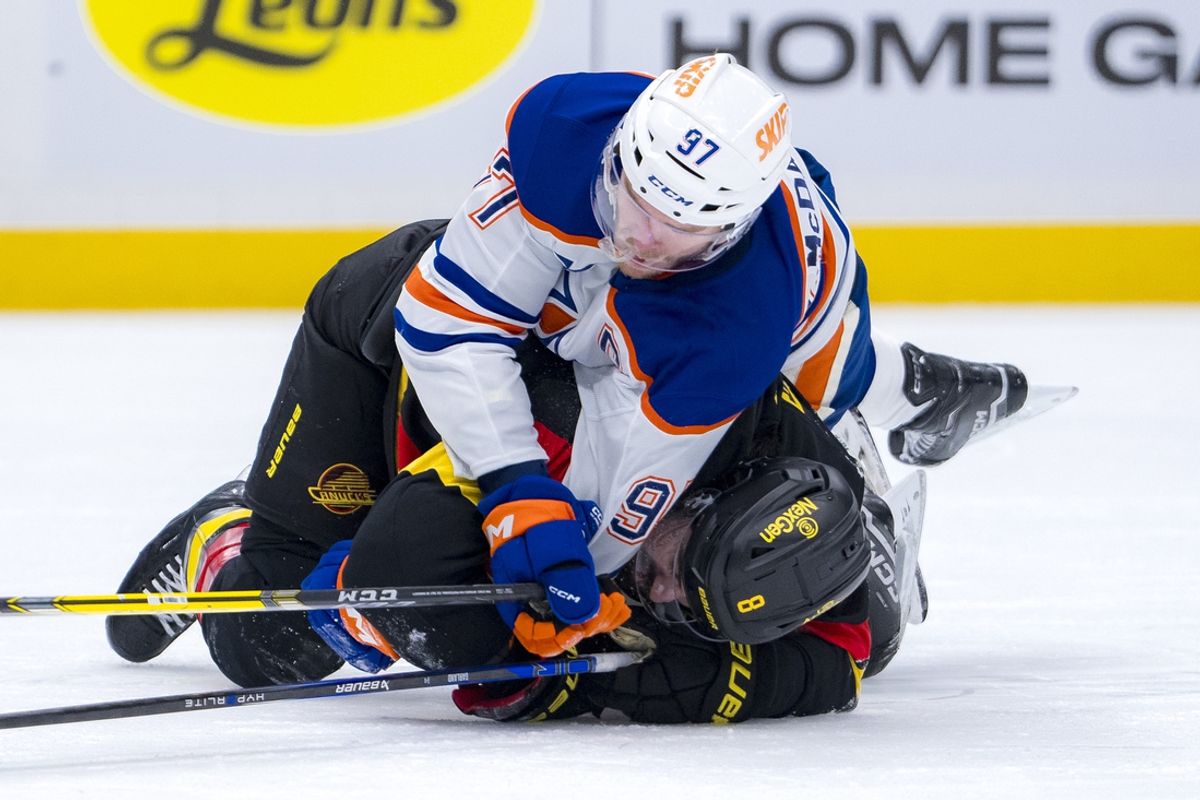 Jan 18, 2025; Vancouver, British Columbia, CAN; Edmonton Oilers forward Connor McDavid (97) battles with Vancouver Canucks forward Conor Garland (8) in the third period at Rogers Arena. Mandatory Credit: Bob Frid-Imagn Images