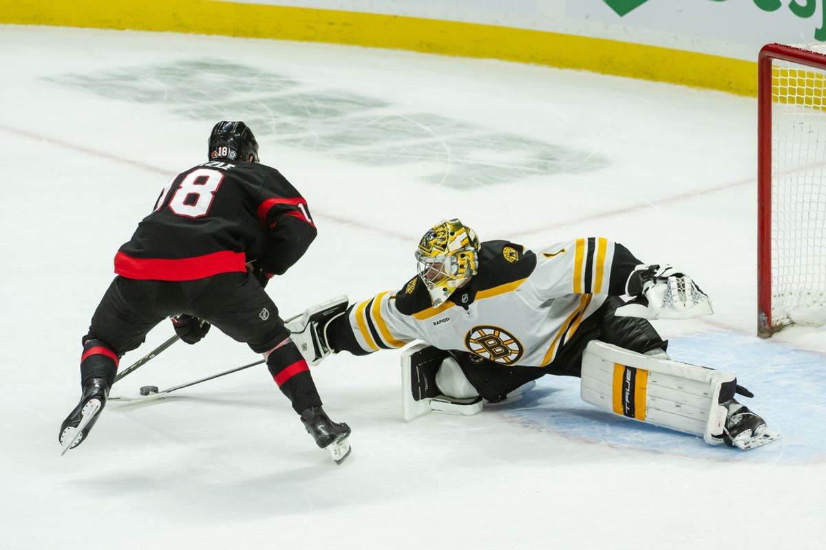 Jan 18, 2025; Ottawa, Ontario, CAN; Ottawa Senators center Tim Stutzle (18) moves the puck out of the reach of  Boston Bruins goalie Jeremy Swayman (1) to score in a shootout at the Canadian Tire Centre. Mandatory Credit: Marc DesRosiers-Imagn Images
