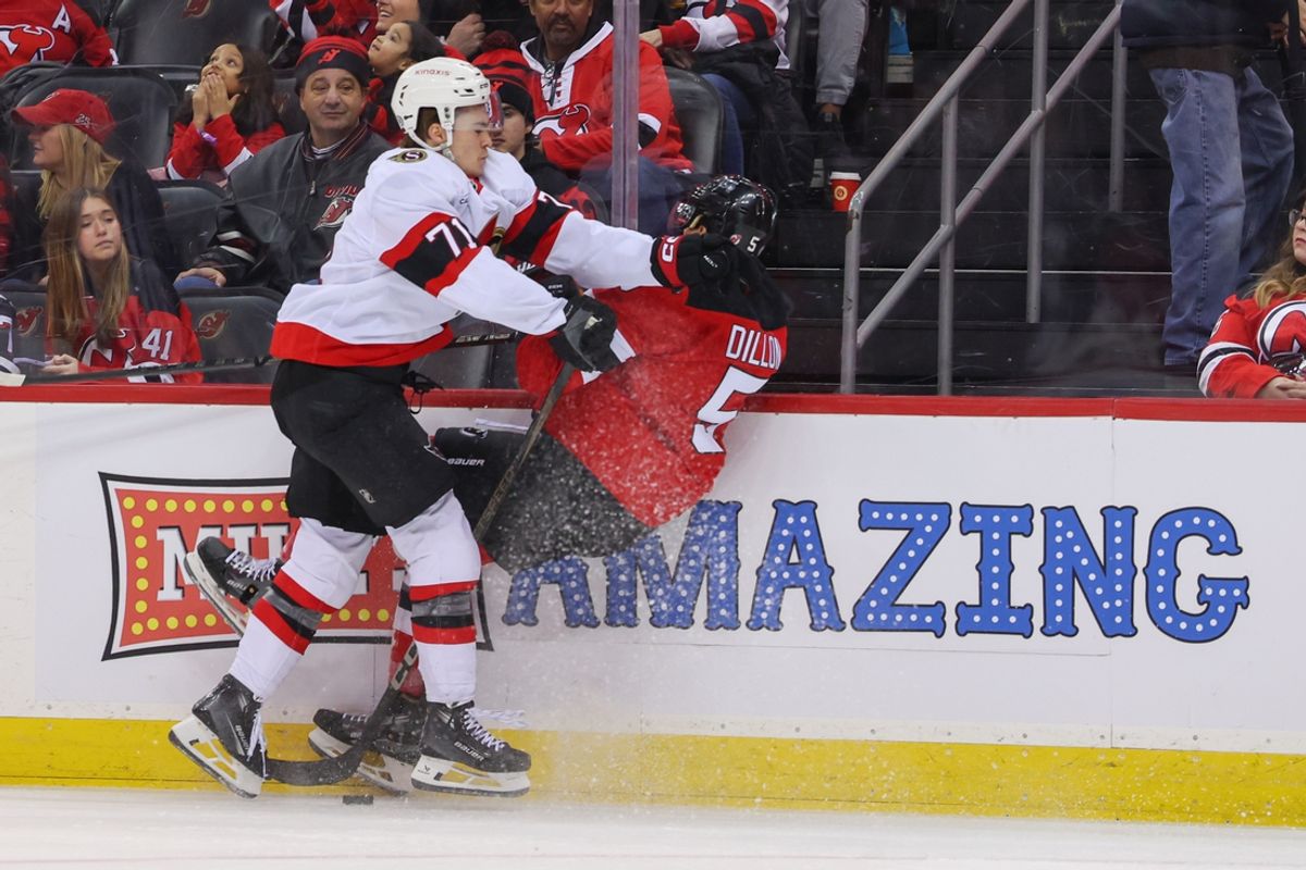 Jan 19, 2025; Newark, New Jersey, USA; Ottawa Senators center Ridly Greig (71) hits New Jersey Devils defenseman Brenden Dillon (5) during the first period at Prudential Center. Mandatory Credit: Ed Mulholland-Imagn Images