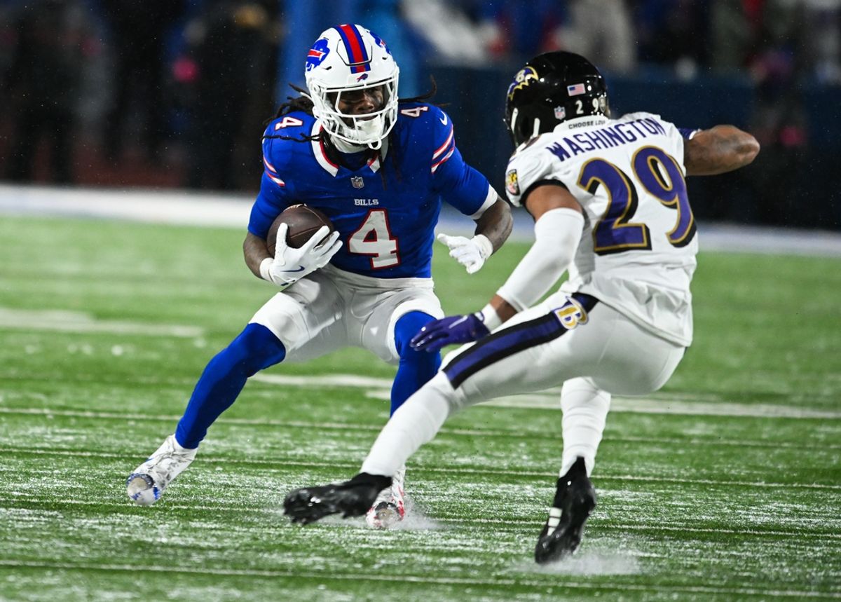 Jan 19, 2025; Orchard Park, New York, USA; Buffalo Bills running back James Cook (4) runs the ball against Baltimore Ravens safety Ar'Darius Washington (29) during the fourth quarter in a 2025 AFC divisional round game at Highmark Stadium. Mandatory Credit: Mark Konezny-Imagn Images