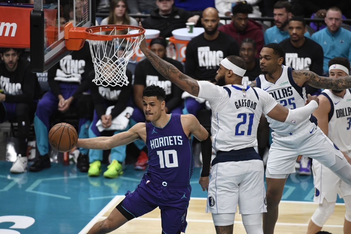 Jan 20, 2025; Charlotte, North Carolina, USA;  Charlotte Hornets guard Josh Green (10) passes as he is guarded by Dallas Mavericks center Daniel Gafford (21) during the first half at the Spectrum Center. Mandatory Credit: Sam Sharpe-Imagn Images