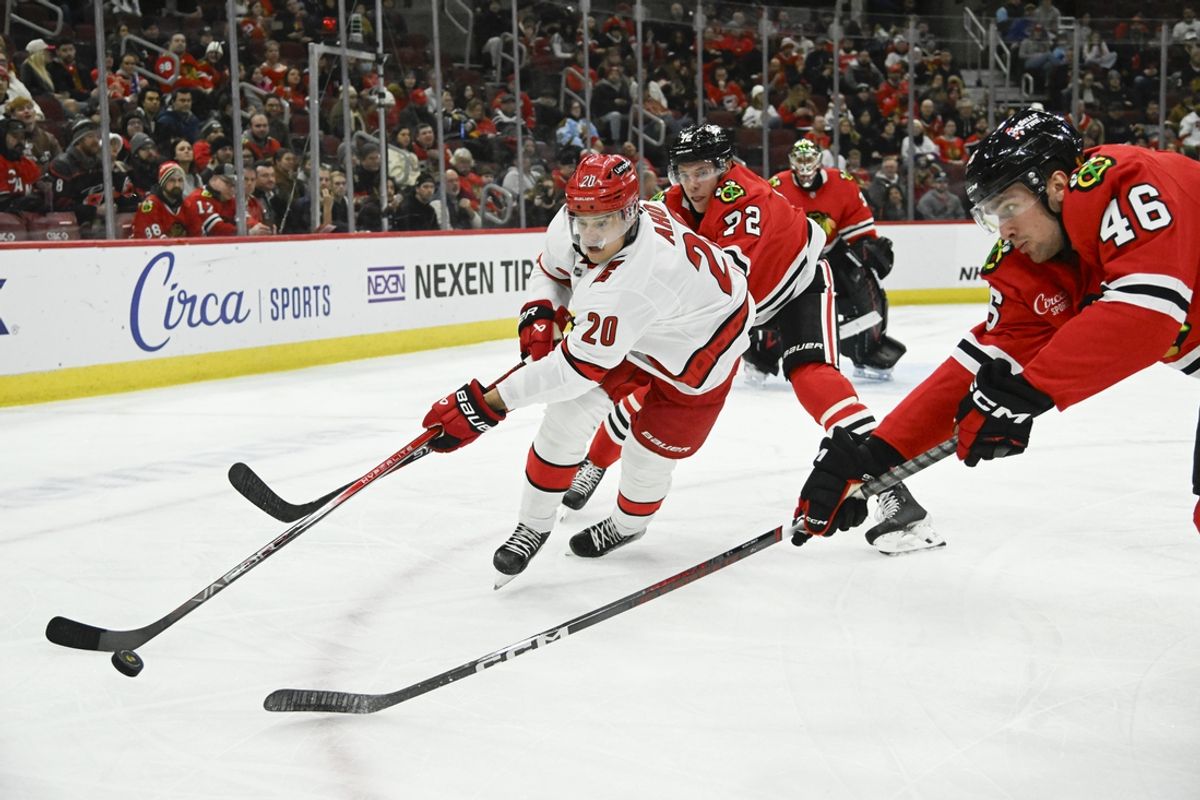 Jan 20, 2025; Chicago, Illinois, USA;  Carolina Hurricanes center Sebastian Aho (20) moves the puck against Chicago Blackhawks defenseman Louis Crevier (46) during the first period at the United Center. Mandatory Credit: Matt Marton-Imagn Images