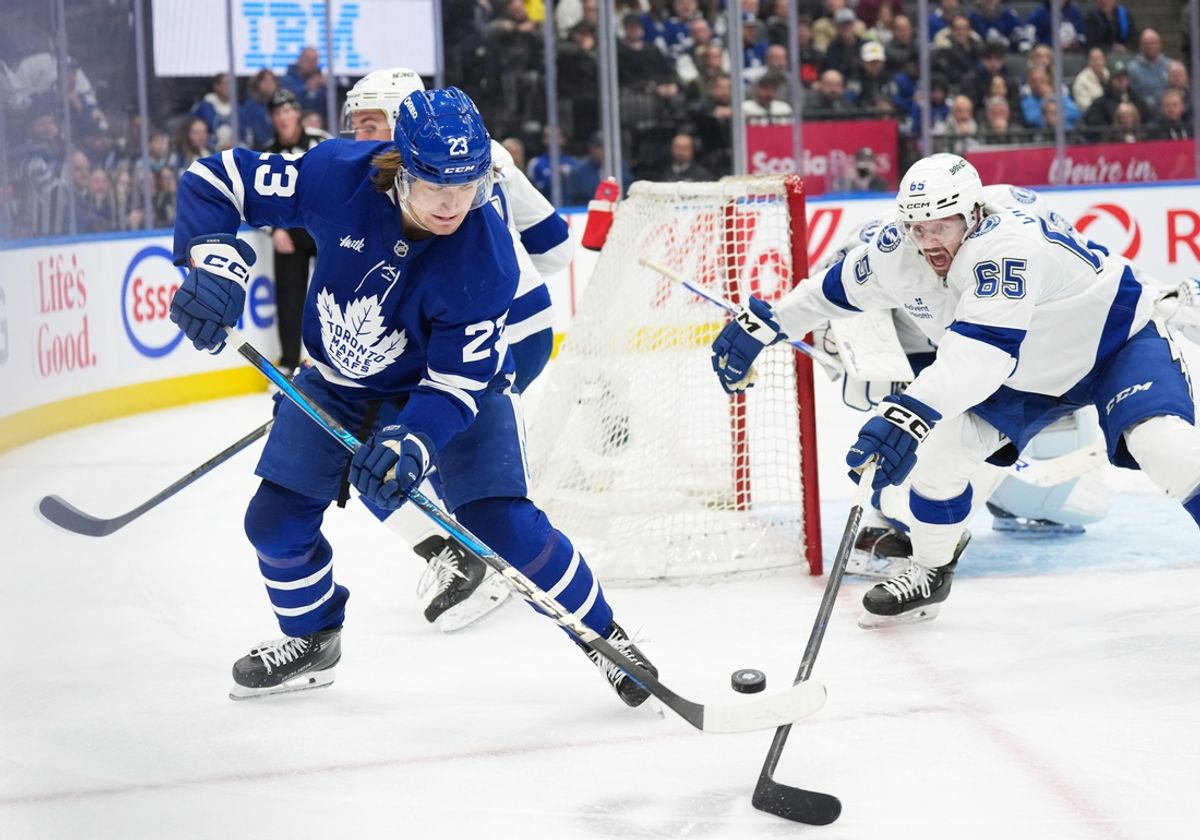 Jan 20, 2025; Toronto, Ontario, CAN; Toronto Maple Leafs left wing Matthew Knies (23) battles for the puck with Tampa Bay Lightning  defenceman Maxwell Crozier (65) during the third period at Scotiabank Arena. Mandatory Credit: Nick Turchiaro-Imagn Images