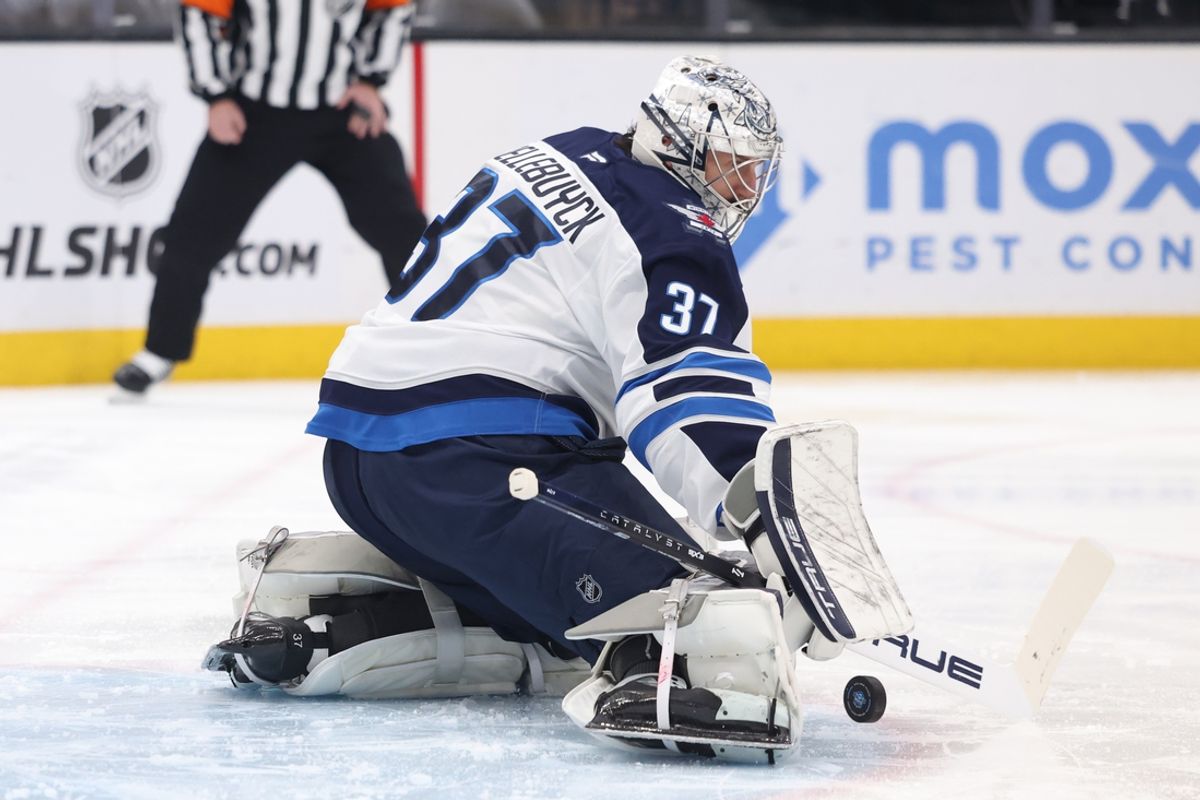 Jan 20, 2025; Salt Lake City, Utah, USA; Winnipeg Jets goaltender Connor Hellebuyck (37) blocks a shot by the Utah Hockey Club during the second period at Delta Center. Mandatory Credit: Rob Gray-Imagn Images