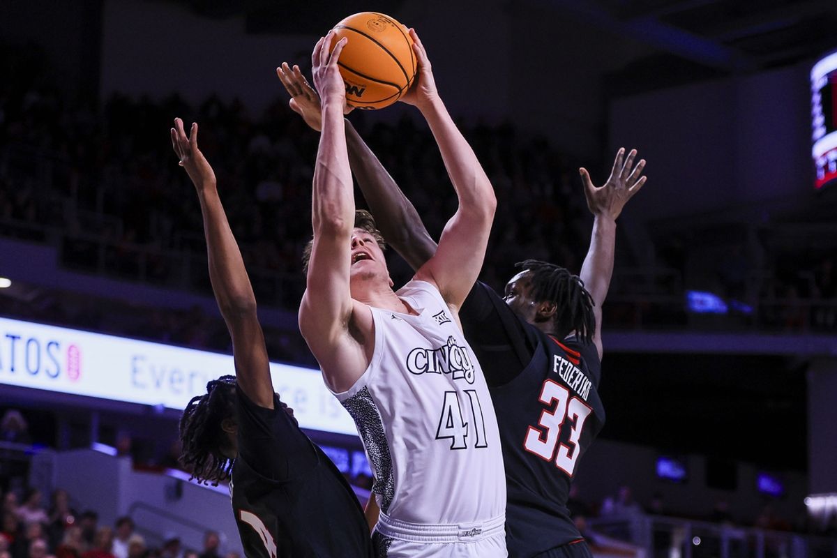 Jan 21, 2025; Cincinnati, Ohio, USA; Cincinnati Bearcats guard Simas Lukosius (41) shoots against Texas Tech Red Raiders guard Christian Anderson (4) and forward Federiko Federiko (33) in the first half at Fifth Third Arena. Mandatory Credit: Katie Stratman-Imagn Images