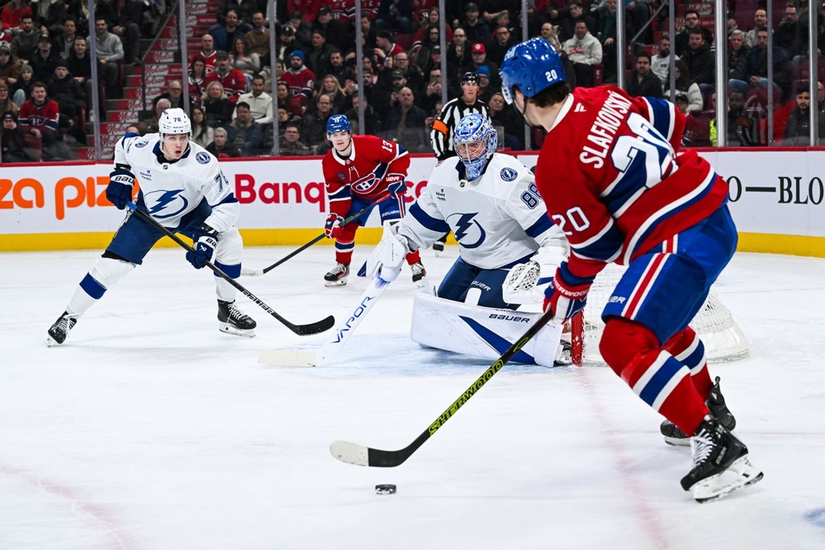 Jan 21, 2025; Montreal, Quebec, CAN; Montreal Canadiens left wing Juraj Slafkovsky (20) plays the puck against Tampa Bay Lightning goalie Andrei Vasilevskiy (88) and defenseman Emil Lilleberg (78) during the first period at Bell Centre. Mandatory Credit: David Kirouac-Imagn Images