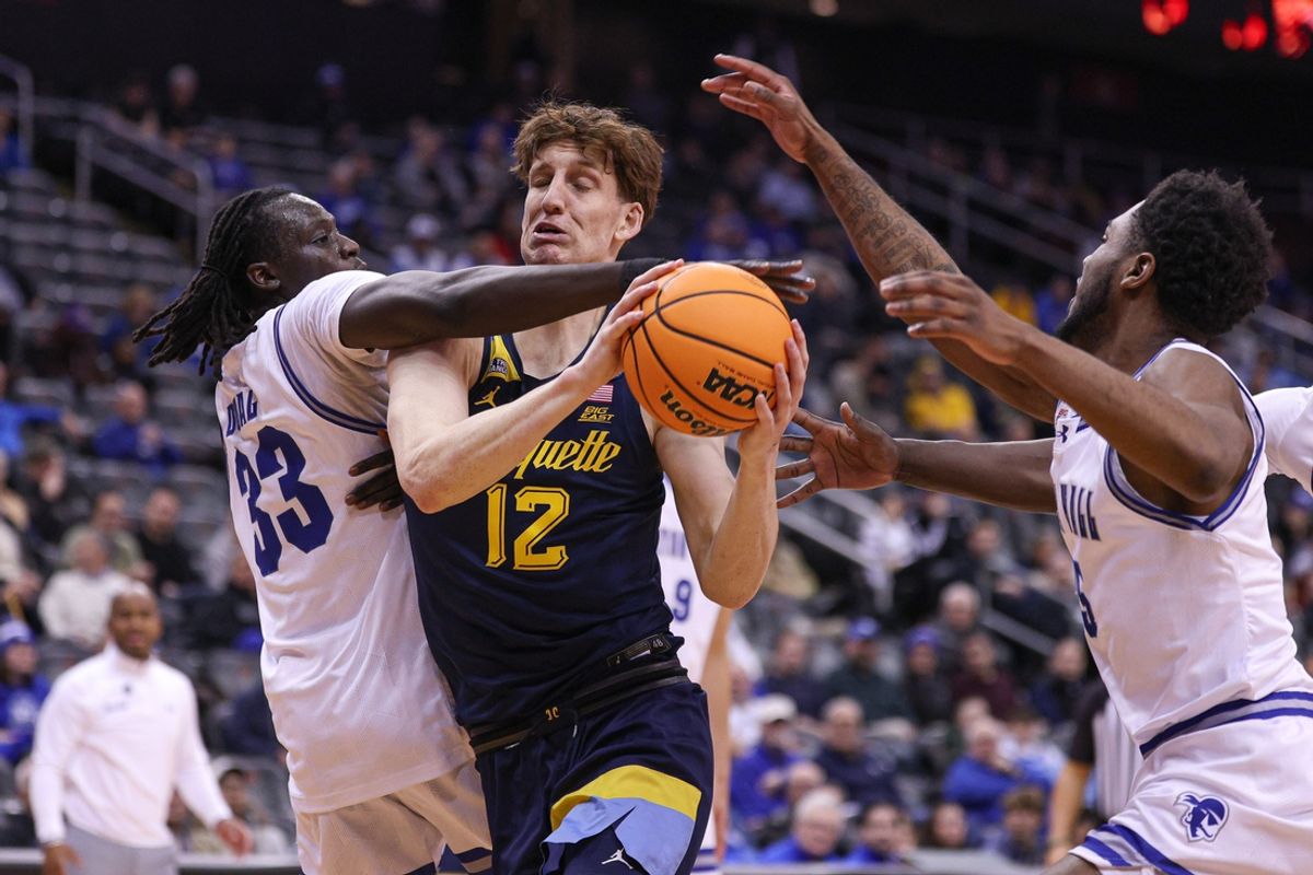Jan 21, 2025; Newark, New Jersey, USA; Marquette Golden Eagles forward Ben Gold (12) goes to the basket asSeton Hall Pirates guard Garwey Dual (33) and guard Jahseem Felton (15) defend during the first half at Prudential Center. Mandatory Credit: Vincent Carchietta-Imagn Images