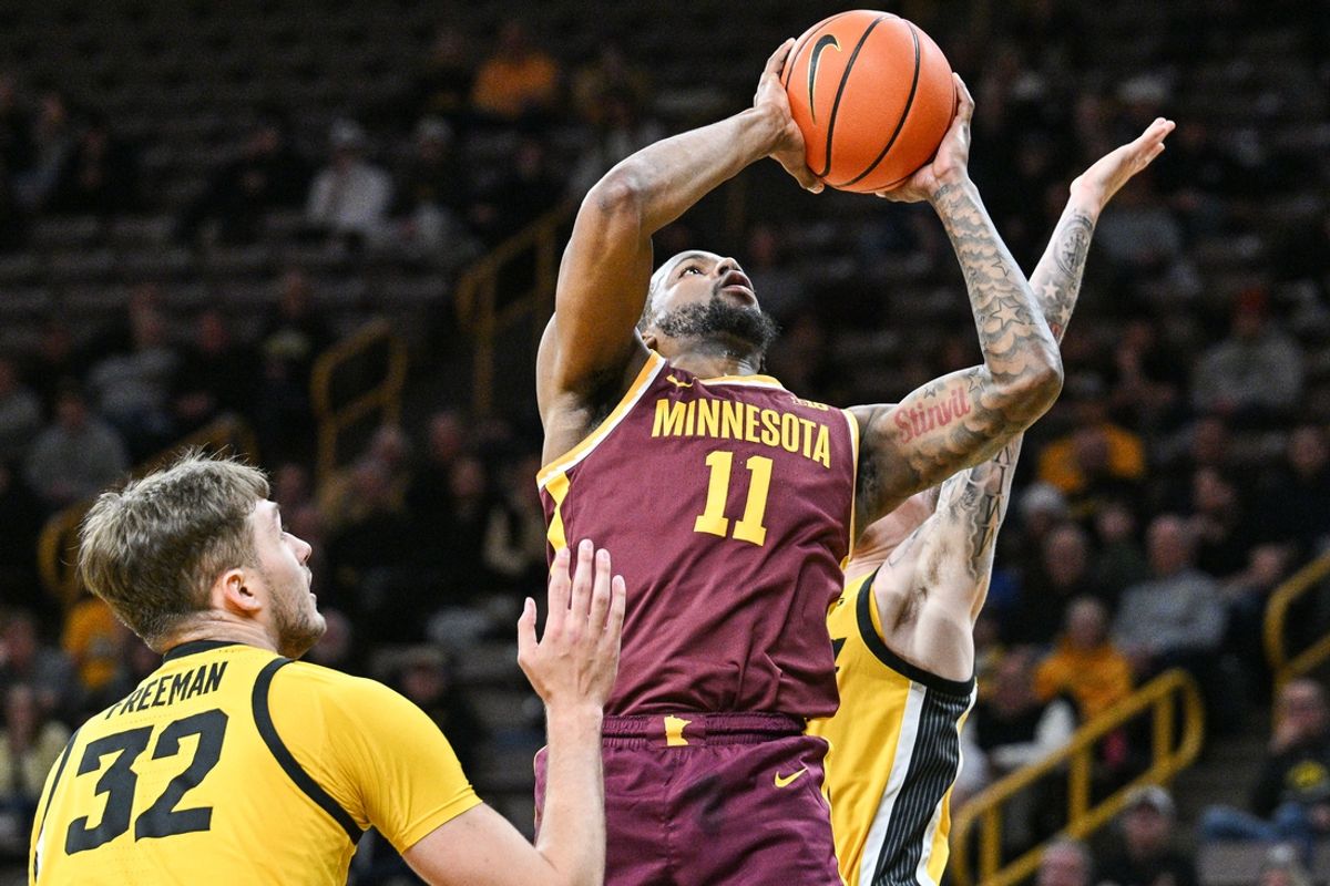 Jan 21, 2025; Iowa City, Iowa, USA; Minnesota Golden Gophers guard Femi Odukale (11) goes to the basket as Iowa Hawkeyes forward Owen Freeman (32) and Iowa Hawkeyes guard Brock Harding (rear) defend during the first half at Carver-Hawkeye Arena. Mandatory Credit: Jeffrey Becker-Imagn Images