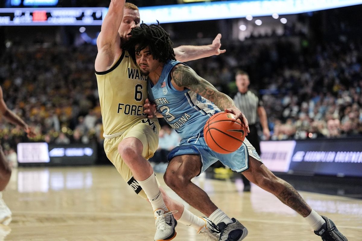 Jan 21, 2025; Winston-Salem, North Carolina, USA;  North Carolina Tar Heels guard Elliot Cadeau (3) drives to the basket defended by Wake Forest Demon Deacons guard Cameron Hildreth (6) during the first half  at Lawrence Joel Veterans Memorial Coliseum. Mandatory Credit: Jim Dedmon-Imagn Images