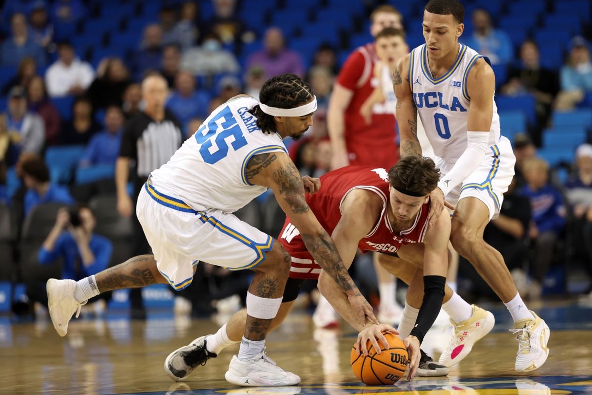 Jan 21, 2025; Los Angeles, California, USA;  Wisconsin Badgers forward Carter Gilmore (7) fights for a loose ball against UCLA Bruins guard Skyy Clark (55) and UCLA Bruins guard Kobe Johnson (0) during the first half at Pauley Pavilion presented by Wescom. Mandatory Credit: Kiyoshi Mio-Imagn Images