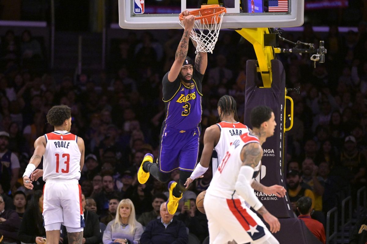Jan 21, 2025; Los Angeles, California, USA;  Los Angeles Lakers forward Anthony Davis (3) hangs on the rim after a dunk in the first half against the Washington Wizards at Crypto.com Arena. Mandatory Credit: Jayne Kamin-Oncea-Imagn Images