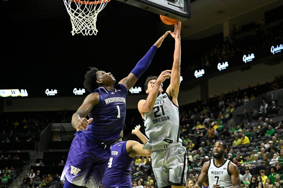 Jan 21, 2025; Eugene, Oregon, USA; Washington Huskies forward Great Osobor (1) defends a drive to the basket by Oregon Ducks forward Brandon Angel (21) during the first half at Matthew Knight Arena. Mandatory Credit: Craig Strobeck-Imagn Images
