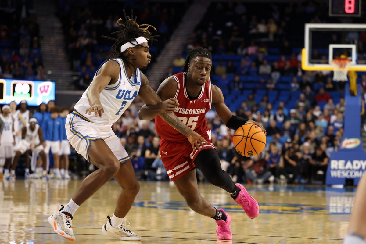 Jan 21, 2025; Los Angeles, California, USA;  Wisconsin Badgers guard John Blackwell (25) dribbles the ball against UCLA Bruins guard Dylan Andrews (2) during the second half at Pauley Pavilion presented by Wescom. Mandatory Credit: Kiyoshi Mio-Imagn Images