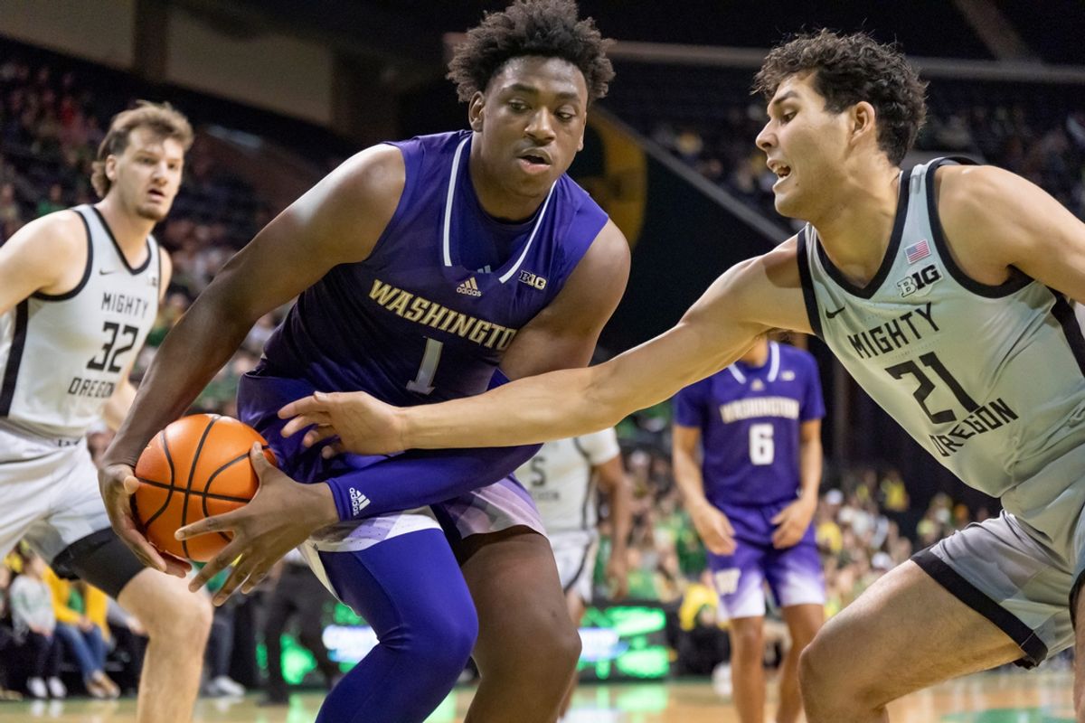 Oregon forward Brandon Angel, right, attempts to steal the ball from Washington forward Great Osobor as the Oregon Ducks host the Washington Huskies Tuesday, Jan. 21, 2025, at Matthew Knight Arena in Eugene, Ore.