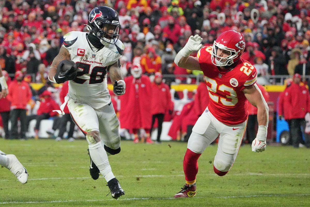 Jan 18, 2025; Kansas City, Missouri, USA; Houston Texans running back Joe Mixon (28) runs the ball as Kansas City Chiefs linebacker Drue Tranquill (23) defends during the second half of a 2025 AFC divisional round game at GEHA Field at Arrowhead Stadium. Mandatory Credit: Denny Medley-Imagn Images