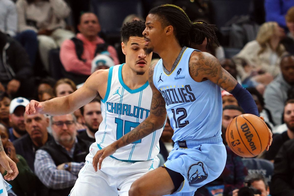 Jan 22, 2025; Memphis, Tennessee, USA; Memphis Grizzlies guard Ja Morant (12) drives to the basket as Charlotte Hornets guard Josh Green (10) defends during the second quarter at FedExForum. Mandatory Credit: Petre Thomas-Imagn Images