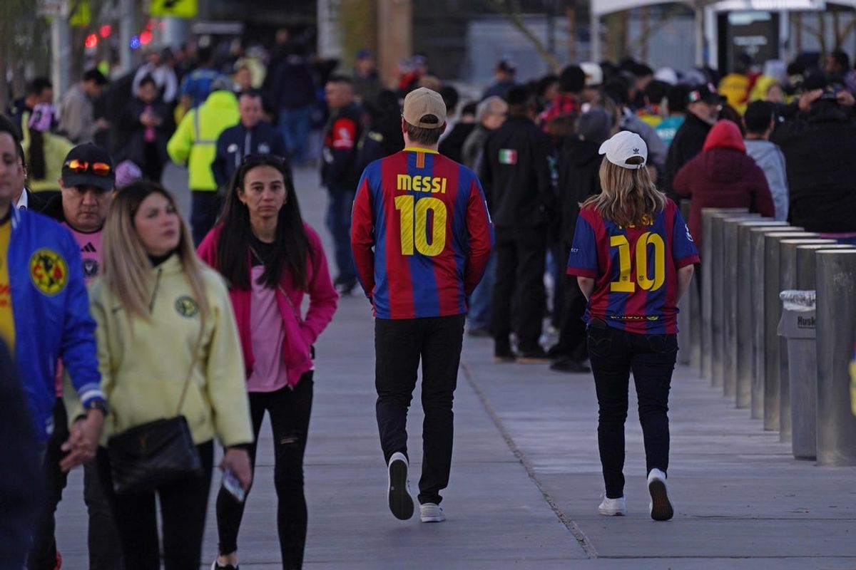 Jan 18, 2025; Las Vegas, Nevada, USA;  Fans wearing the FC Barcelona jersey of Inter Miami CF forward Lionel Messi (10) walk toward the entrance of the stadium before the match against Club America at Allegiant Stadium. Mandatory Credit: David Gonzales-Imagn Images