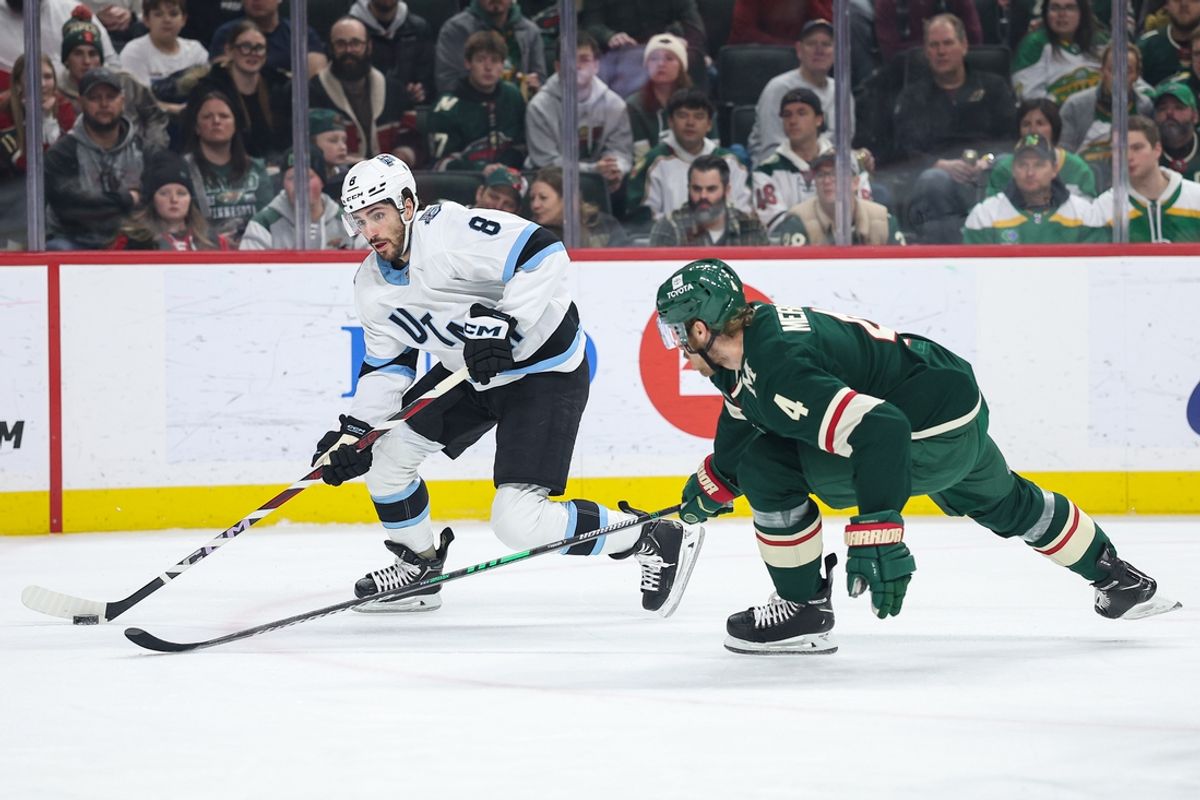 Jan 23, 2025; Saint Paul, Minnesota, USA; Utah Hockey Club center Nick Schmaltz (8) skates with the puck as Minnesota Wild defenseman Jon Merrill (4) defends during the first period at Xcel Energy Center. Mandatory Credit: Matt Krohn-Imagn Images