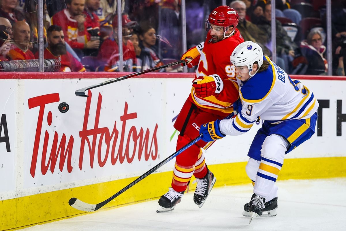 Jan 23, 2025; Calgary, Alberta, CAN; Buffalo Sabres left wing Zach Benson (9) and Calgary Flames center Nazem Kadri (91) battles for the puck during the first period at Scotiabank Saddledome. Mandatory Credit: Sergei Belski-Imagn Images