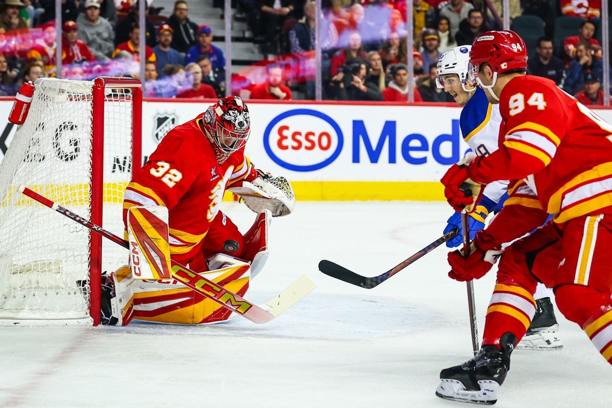 Jan 23, 2025; Calgary, Alberta, CAN; Calgary Flames goaltender Dustin Wolf (32) makes a save against Buffalo Sabres center Peyton Krebs (19) during the first period at Scotiabank Saddledome. Mandatory Credit: Sergei Belski-Imagn Images
