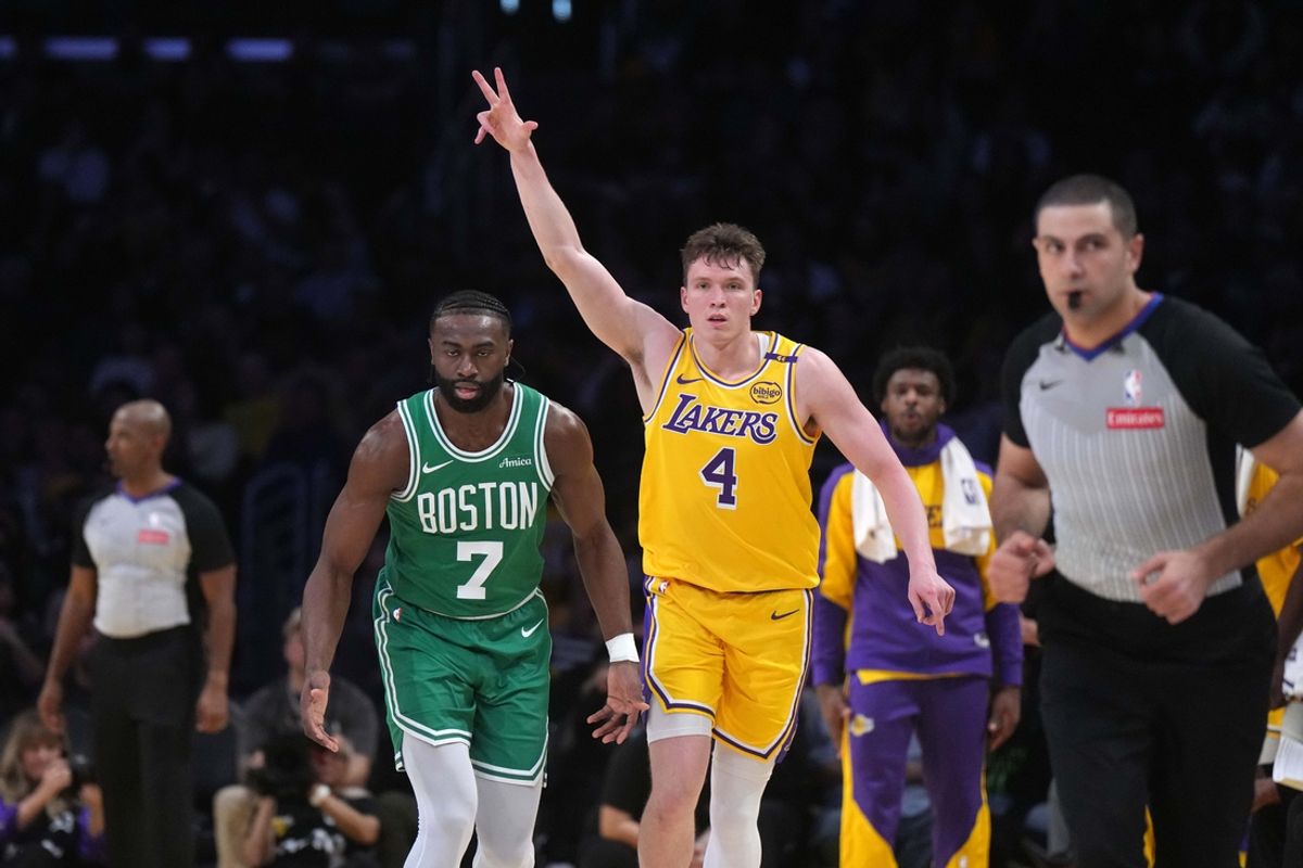 Jan 23, 2025; Los Angeles, California, USA; Los Angeles Lakers guard Dalton Knecht (4) celebrates after a three-point basket as Boston Celtics guard Jaylen Brown (7) watches in the first half at Crypto.com Arena. Mandatory Credit: Kirby Lee-Imagn Images