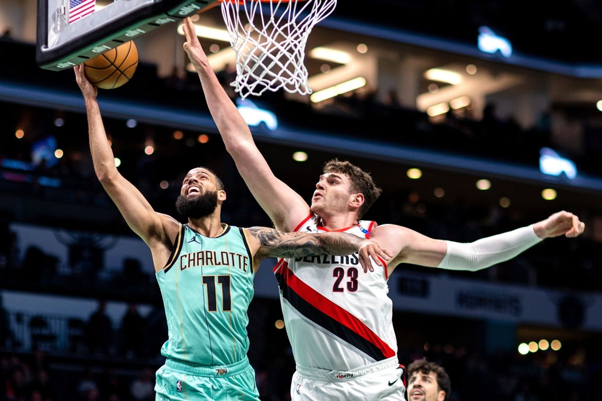 Jan 24, 2025; Charlotte, North Carolina, USA; Charlotte Hornets forward Cody Martin (11) shoots around Portland Trail Blazers center Donovan Clingan (23) during the first quarter at Spectrum Center. Mandatory Credit: Scott Kinser-Imagn Images