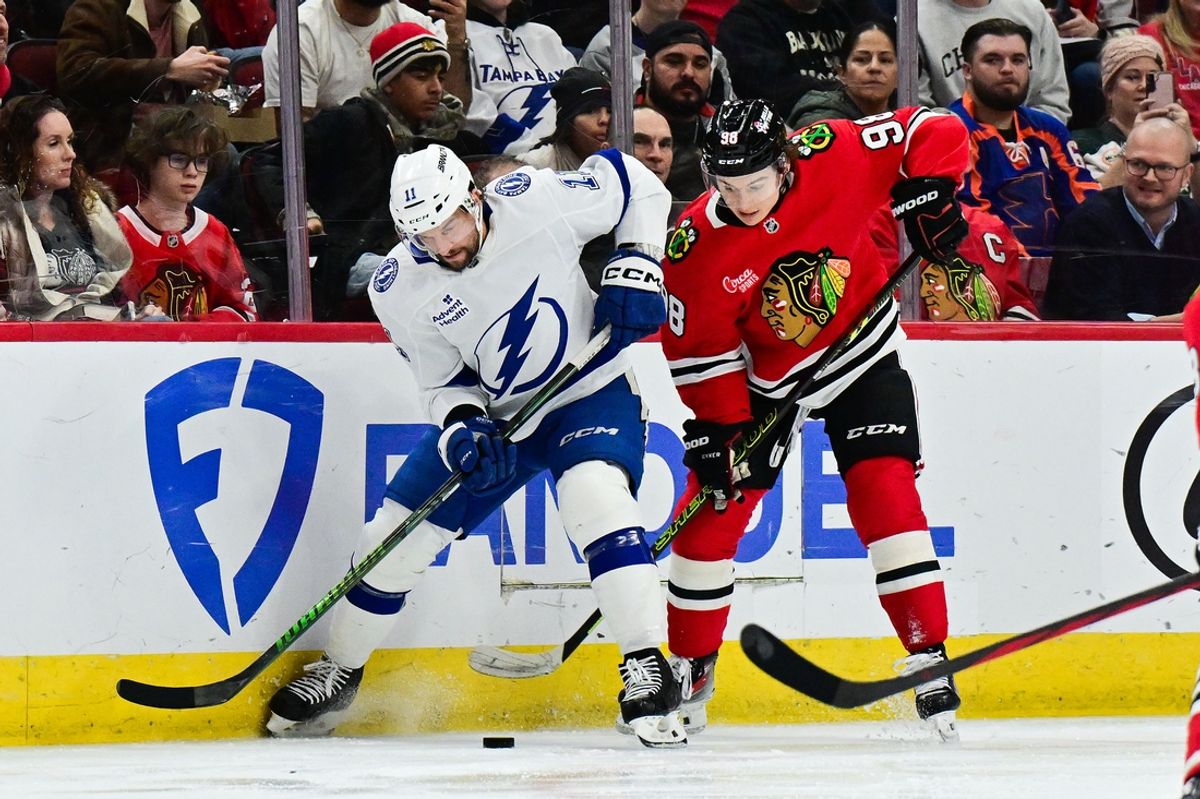Jan 24, 2025; Chicago, Illinois, USA; Tampa Bay Lightning center Luke Glendening (11) and Chicago Blackhawks center Connor Bedard (98) battle for the puck during the second period at the United Center. Mandatory Credit: Daniel Bartel-Imagn Images