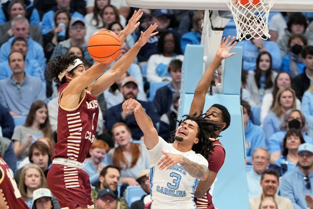 Jan 25, 2025; Chapel Hill, North Carolina, USA;  North Carolina Tar Heels guard Elliot Cadeau (3) passes the ball as Boston College Eagles guard Dion Brown (1) and guard Fred Payne (5) defend in the first half at Dean E. Smith Center. Mandatory Credit: Bob Donnan-Imagn Images