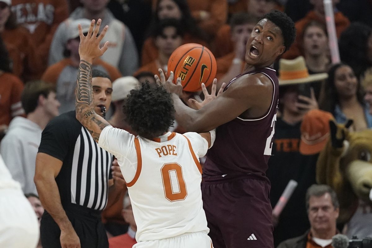 Jan 25, 2025; Austin, Texas, USA; Texas A&M Aggies forward Pharrel Payne (21) looks to pass the ball while defended by Texas Longhorns guard Jordan Pope (0) during the first half at Moody Center. Mandatory Credit: Scott Wachter-Imagn Images