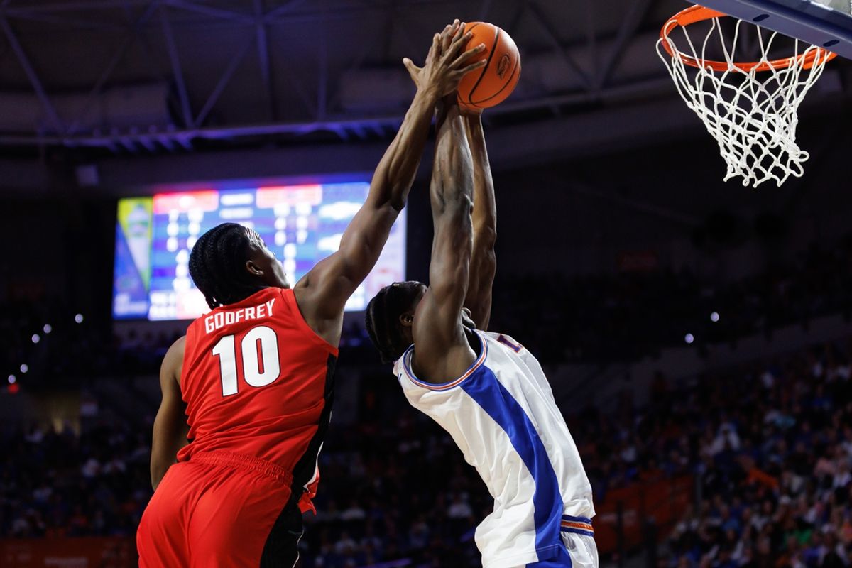 Jan 25, 2025; Gainesville, Florida, USA; Florida Gators center Rueben Chinyelu (9) grabs a rebound over Georgia Bulldogs forward RJ Godfrey (10) during the first half at Exactech Arena at the Stephen C. O'Connell Center. Mandatory Credit: Matt Pendleton-Imagn Images