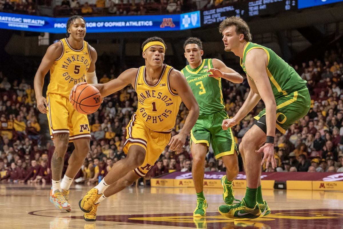 Jan 25, 2025; Minneapolis, Minnesota, USA; Minnesota Golden Gophers guard Isaac Asuma (1) drives to the basket as Oregon Ducks center Nate Bittle (32) defends during the first half at Williams Arena. Mandatory Credit: Nick Wosika-Imagn Images
