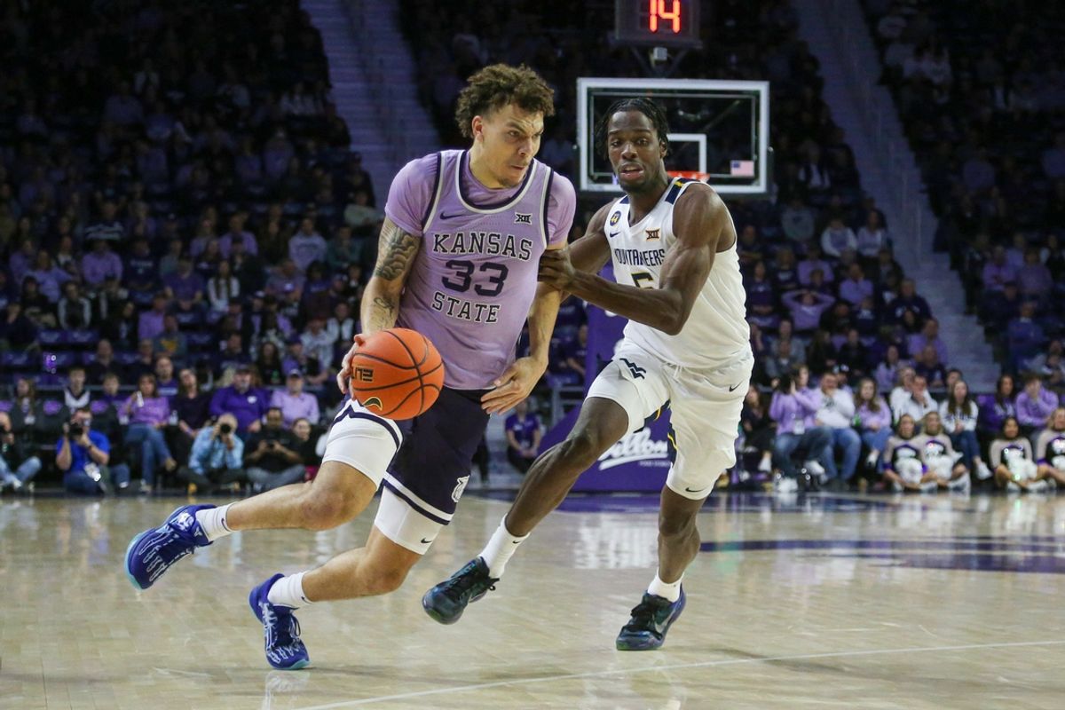 Jan 25, 2025; Manhattan, Kansas, USA; Kansas State Wildcats forward Coleman Hawkins (33) dribbles against West Virginia Mountaineers guard Toby Okani (5) during the first half at Bramlage Coliseum. Mandatory Credit: Scott Sewell-Imagn Images