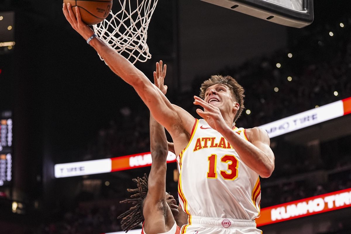 Jan 25, 2025; Atlanta, Georgia, USA; Atlanta Hawks guard Bogdan Bogdanovic (13) goes to the basket past Toronto Raptors guard Ja'Kobe Walter (14) during the first half at State Farm Arena. Mandatory Credit: Dale Zanine-Imagn Images