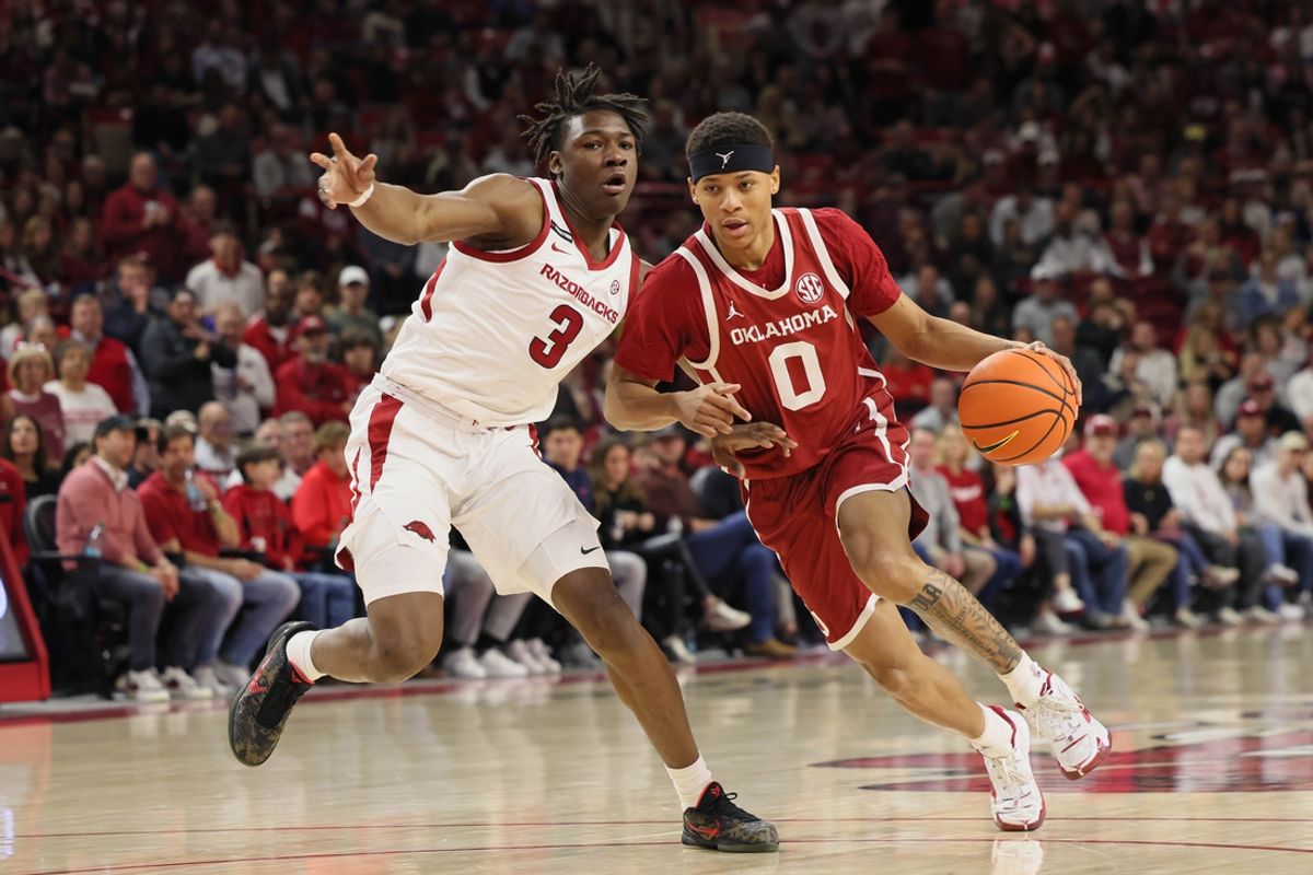 Jan 25, 2025; Fayetteville, Arkansas, USA; Oklahoma Sooners guard Jeremiah Fears (0) drives against Arkansas Razorbacks forward Adou Thiero (3) during the first half at Bud Walton Arena. Mandatory Credit: Nelson Chenault-Imagn Images