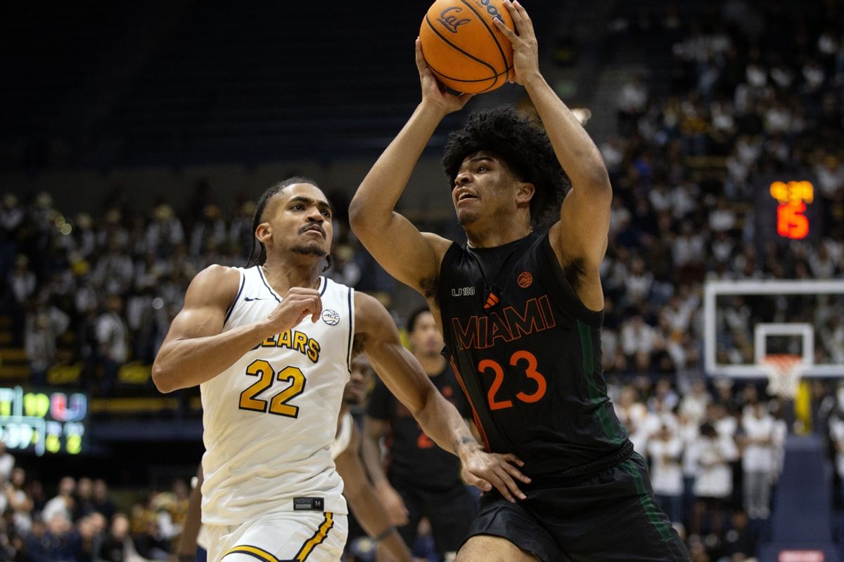Jan 25, 2025; Berkeley, California, USA; Miami Hurricanes guard Austin Swartz (23) drives to the basket against California Golden Bears guard Christian Tucker (22) during the first half at Haas Pavilion. Mandatory Credit: D. Ross Cameron-Imagn Images