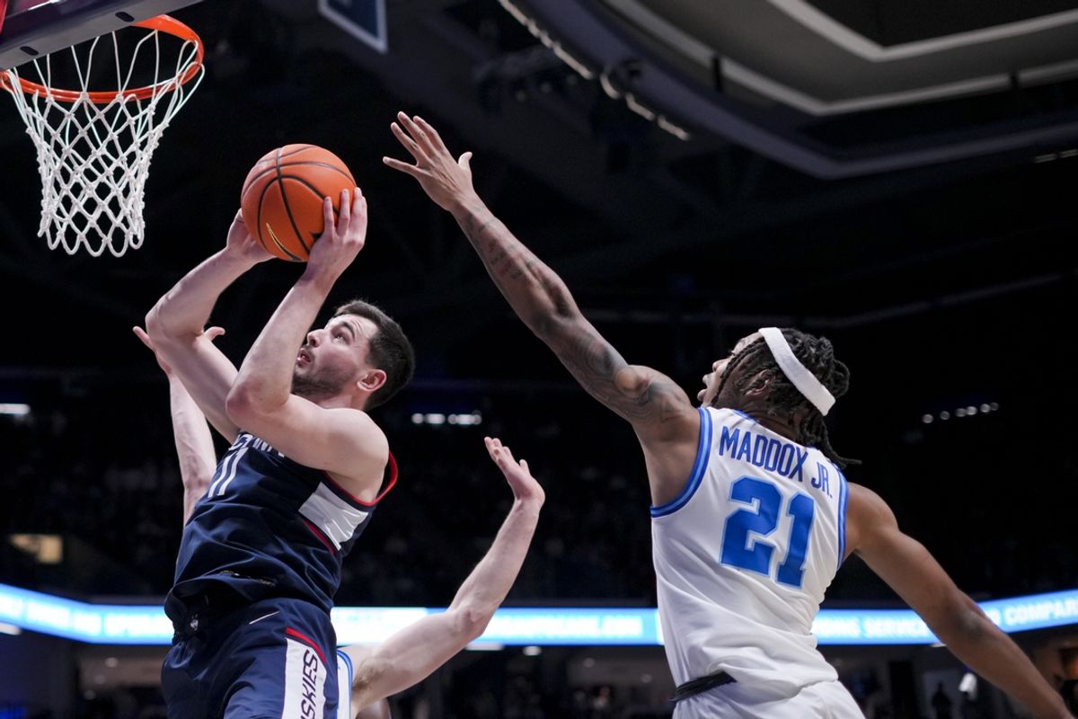 Jan 25, 2025; Cincinnati, Ohio, USA; Connecticut Huskies forward Alex Karaban (11) drives to the basket against Xavier Musketeers guard Dante Maddox Jr. (21) in the second half at the Cintas Center. Mandatory Credit: Aaron Doster-Imagn Images