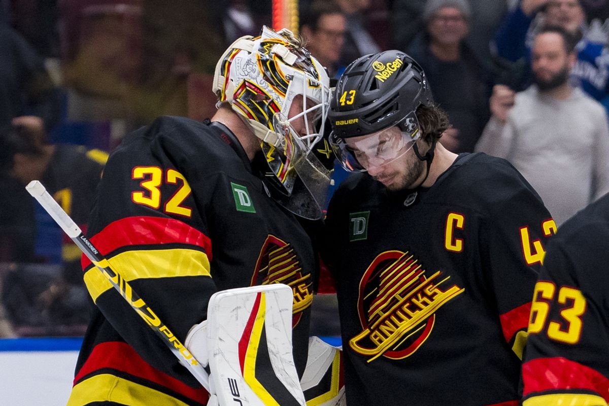 Jan 25, 2025; Vancouver, British Columbia, CAN; Vancouver Canucks goalie Kevin Lankinen (32) and  defenseman Quinn Hughes (43) celebrate the victory against the Washington Capitals at Rogers Arena. Mandatory Credit: Bob Frid-Imagn Images